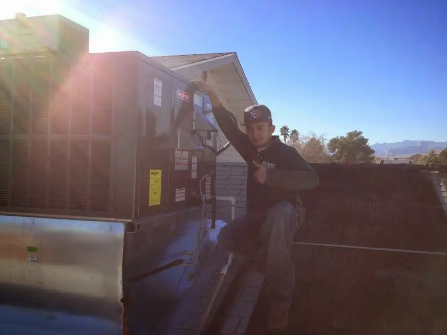 HVAC technician performing Air Duct Cleaning on a rooftop unit in Doctor Phillips